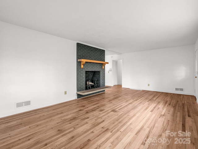 unfurnished living room with wood finished floors, a fireplace, and baseboards