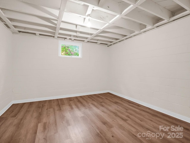 below grade area featuring baseboards and wood finished floors