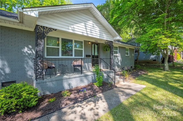 2601 Dora Dr, Charlotte, NC 28215 - view of front facade with brick siding, a porch, and a front yard