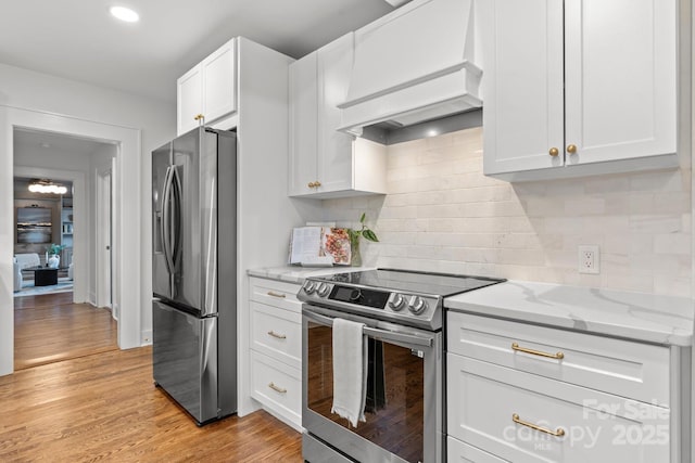 625 4th Street Dr NW, Hickory, NC 28601 - kitchen with light stone countertops, premium range hood, light wood-type flooring, white cabinetry, and stainless steel appliances