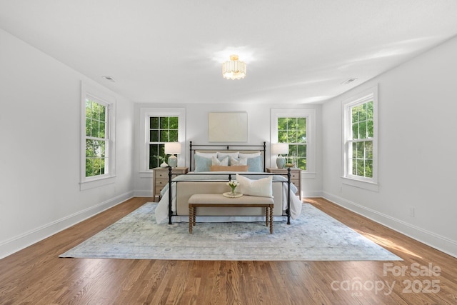 625 4th Street Dr NW, Hickory, NC 28601 - bedroom featuring an inviting chandelier, baseboards, multiple windows, and wood finished floors