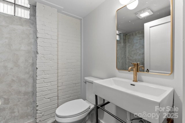 625 4th Street Dr NW, Hickory, NC 28601 - bathroom with a sink, brick wall, and toilet