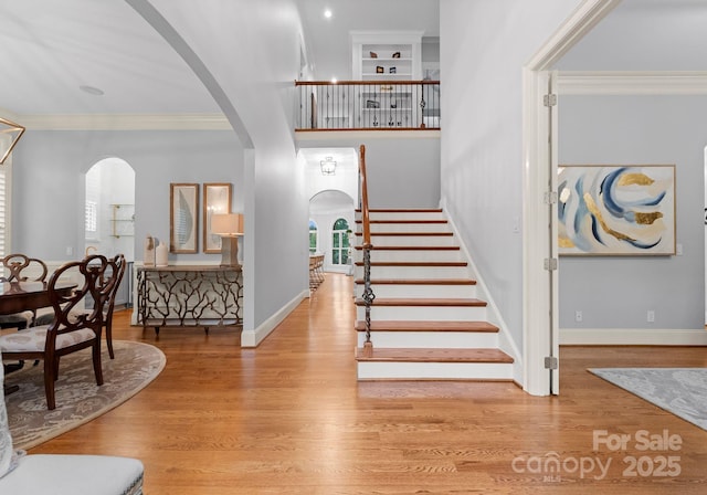 13420 Robert Walker Dr, Davidson, NC 28036 - foyer featuring arched walkways, baseboards, wood finished floors, stairs, and crown molding
