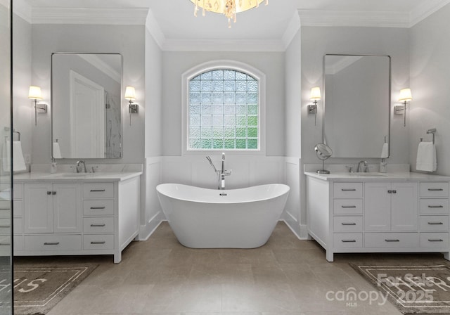 13420 Robert Walker Dr, Davidson, NC 28036 - bathroom featuring wainscoting, two vanities, a soaking tub, and a sink