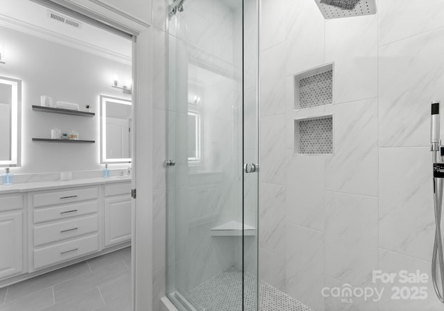 13420 Robert Walker Dr, Davidson, NC 28036 - bathroom with a shower stall, tile patterned floors, double vanity, visible vents, and crown molding