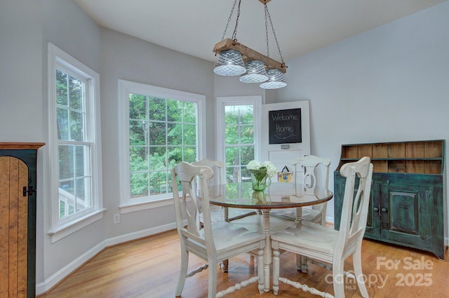 dining space with light wood-style floors, baseboards, and a wealth of natural light