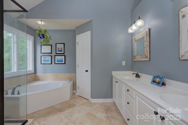 bathroom with double vanity, a bath, a sink, tile patterned floors, and baseboards