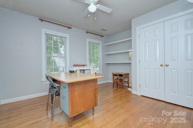 home office with light wood-type flooring, a ceiling fan, baseboards, and visible vents