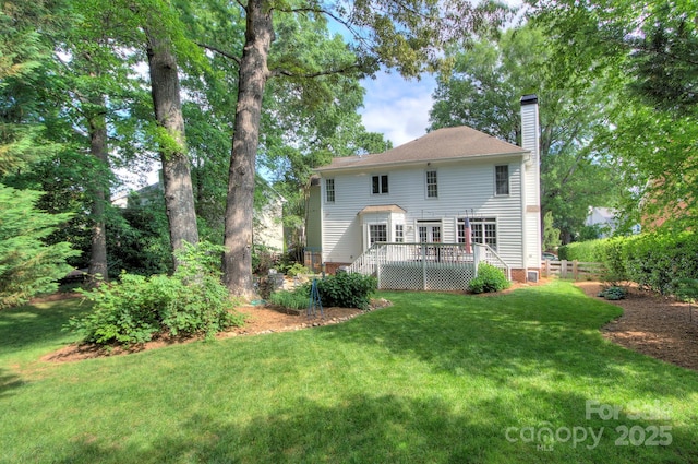 back of house featuring a wooden deck, a yard, and a chimney
