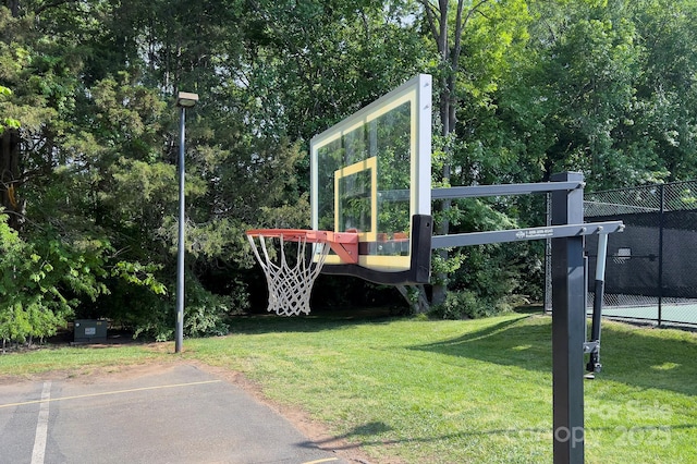 view of sport court featuring a lawn and fence