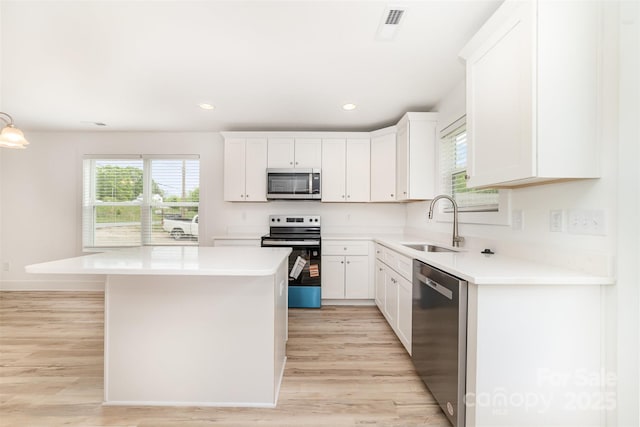 kitchen with light countertops, light wood-style floors, a sink, and stainless steel appliances