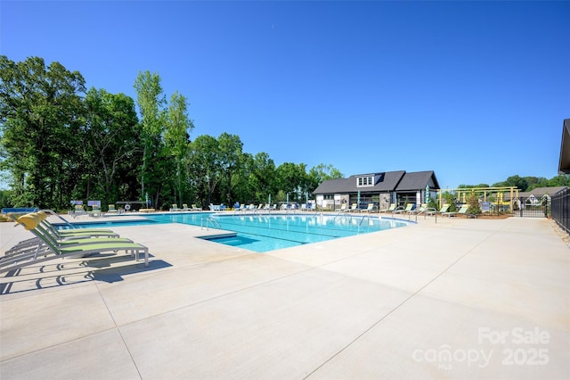 community pool with a patio and fence