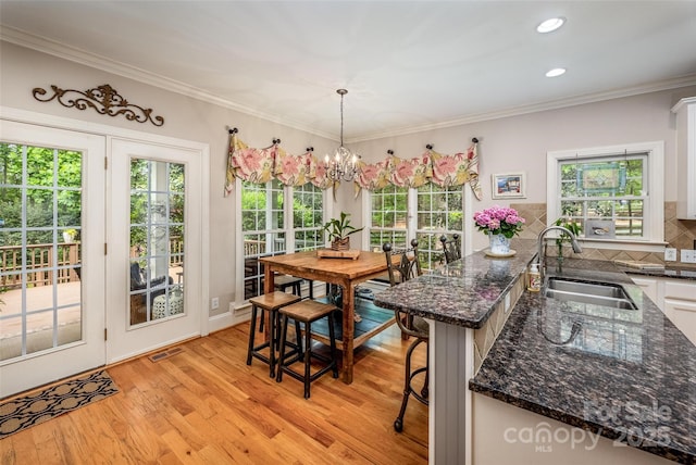 19729 Callaway Hills Ln, Davidson, NC 28036 - dining room featuring light wood finished floors, visible vents, a notable chandelier, and ornamental molding