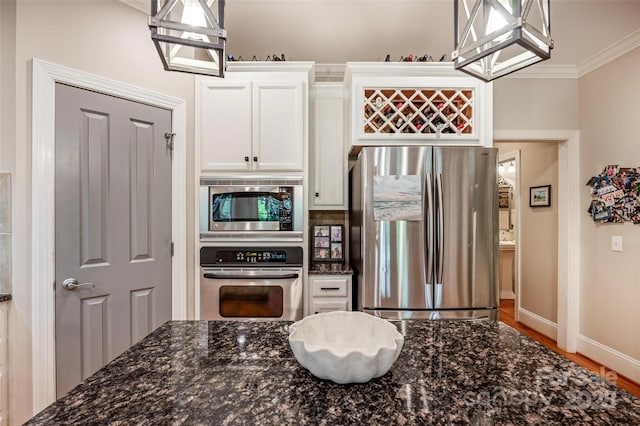 19729 Callaway Hills Ln, Davidson, NC 28036 - kitchen featuring white cabinets, stainless steel appliances, ornamental molding, baseboards, and dark stone counters