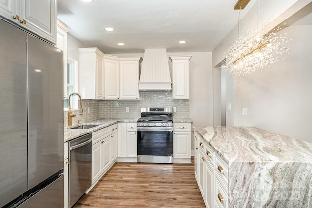 112 Circle Dr, Salisbury, NC 28144 - kitchen with appliances with stainless steel finishes, custom exhaust hood, a sink, light wood-type flooring, and white cabinets