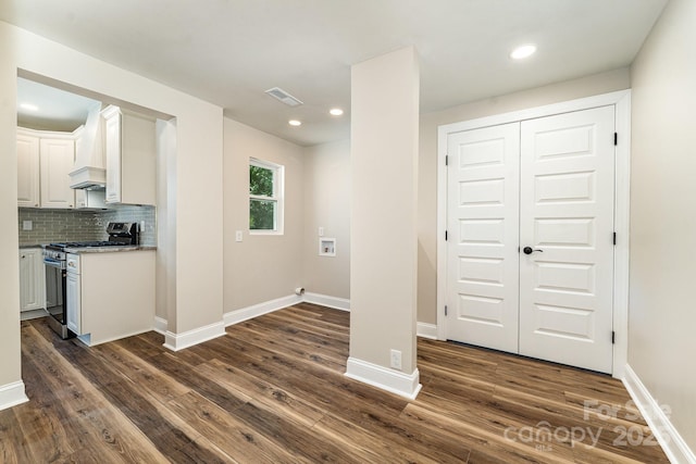 112 Circle Dr, Salisbury, NC 28144 - kitchen with stainless steel range with gas stovetop, dark wood-style floors, custom range hood, white cabinetry, and decorative backsplash