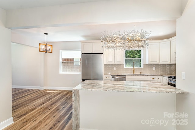 112 Circle Dr, Salisbury, NC 28144 - kitchen with a chandelier, appliances with stainless steel finishes, a sink, wood finished floors, and backsplash
