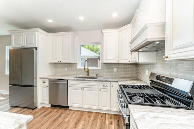 112 Circle Dr, Salisbury, NC 28144 - kitchen with stainless steel appliances, a sink, custom range hood, white cabinets, and light wood finished floors