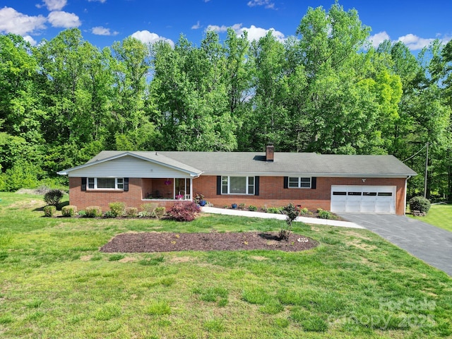 ranch-style house with an attached garage, a chimney, driveway, and brick siding