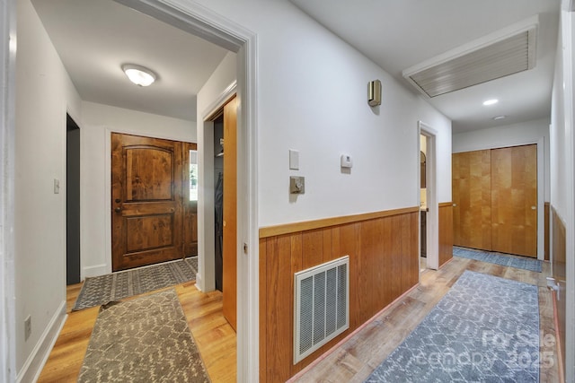 corridor featuring attic access, light wood-style flooring, and visible vents