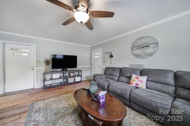 living area featuring crown molding, ceiling fan, and wood finished floors