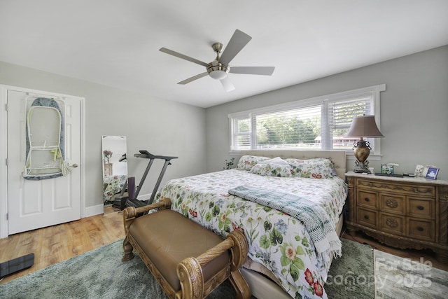 bedroom with baseboards, a ceiling fan, and wood finished floors
