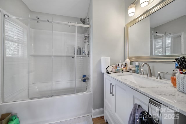 full bath featuring vanity, baseboards, and shower / bath combination with glass door