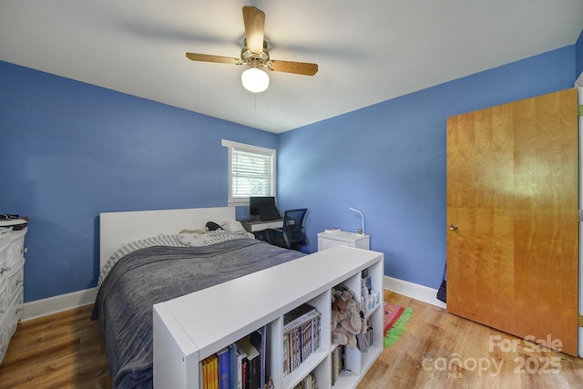bedroom featuring baseboards, ceiling fan, and wood finished floors