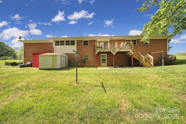 rear view of property featuring stairway, brick siding, a wooden deck, and a storage unit