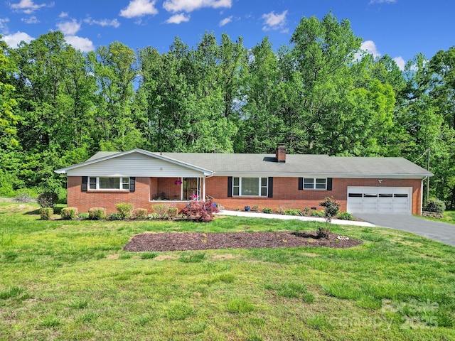 ranch-style house featuring a front yard, a chimney, brick siding, an attached garage, and a porch