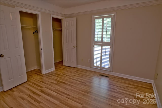 10708 Danesway Ln, Cornelius, NC 28031 - unfurnished bedroom featuring baseboards, light wood-style flooring, visible vents, and multiple closets