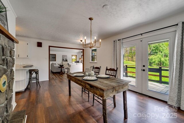 dining room with a textured ceiling, dark wood finished floors, and french doors