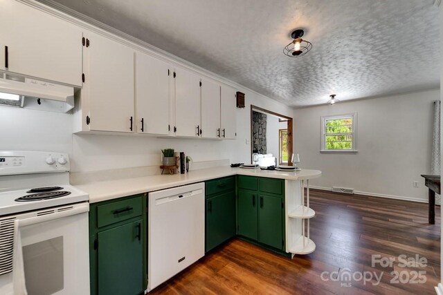 kitchen featuring visible vents, light countertops, a peninsula, under cabinet range hood, and white appliances