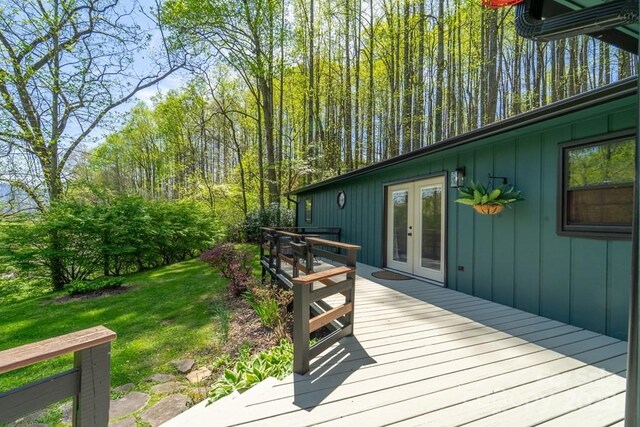 wooden deck with a lawn and french doors