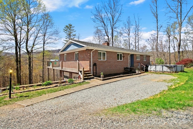 675 Rodgers Rd, Newland, NC 28657 - back of house with a chimney, gravel driveway, brick siding, and a covered pool