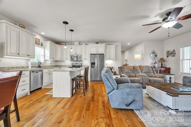 living room featuring light wood finished floors, recessed lighting, and ceiling fan