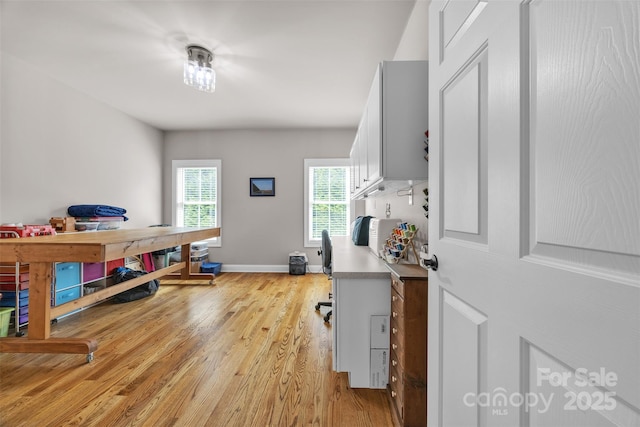 office space with baseboards and light wood-style floors