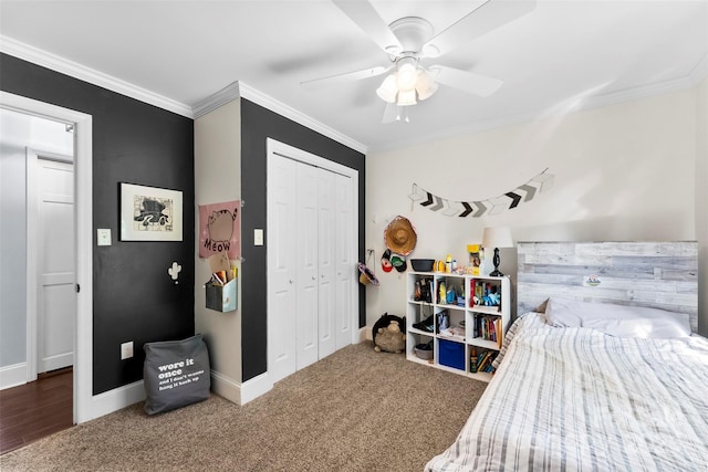 bedroom with a closet, crown molding, carpet flooring, baseboards, and a ceiling fan