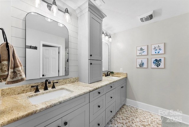 full bath featuring visible vents, a sink, and double vanity