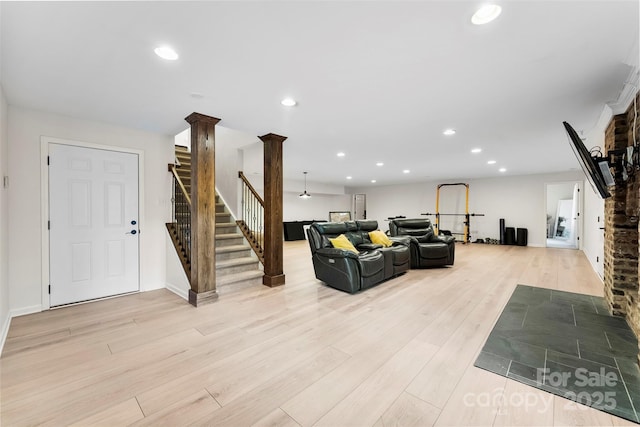 living area featuring light wood-style floors, recessed lighting, stairs, and ornate columns