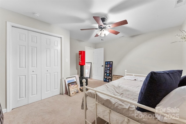 carpeted bedroom with visible vents, ceiling fan, and a closet