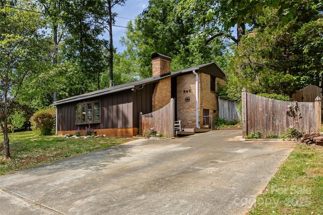 846 Gist Rd, Rock Hill, SC 29732 - exterior space with fence, brick siding, concrete driveway, a chimney, and board and batten siding