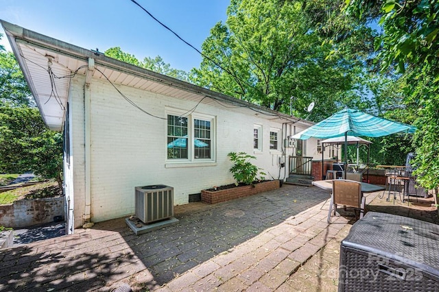 310 1st St NE, Hickory, NC 28601 - back of property featuring brick siding, a patio area, central AC, and outdoor dining space