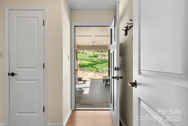 doorway to outside featuring wood finished floors and baseboards