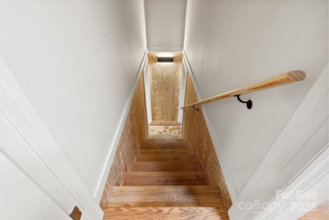 stairs with a wainscoted wall