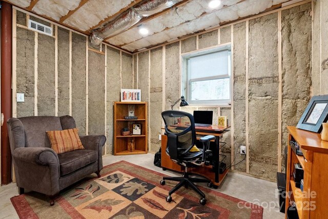 office area with visible vents and unfinished concrete flooring