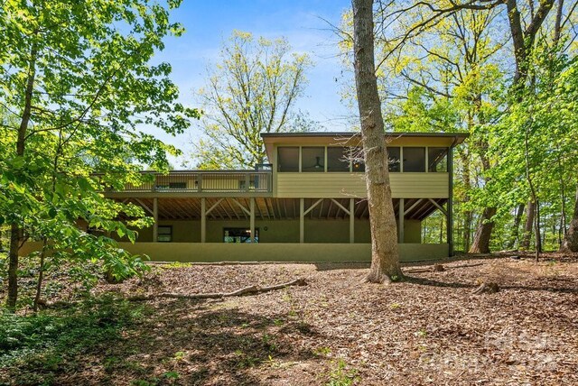 rear view of property with a sunroom and a wooden deck