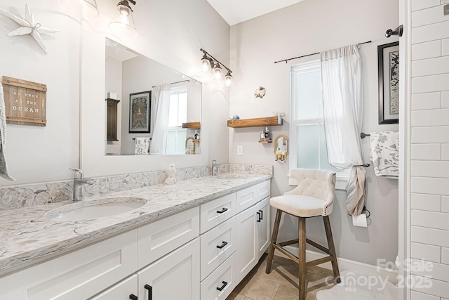 bathroom featuring tile patterned flooring, a sink, and double vanity
