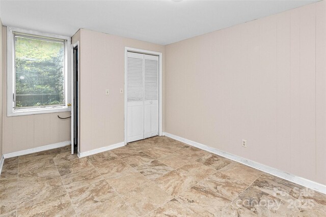 159 Amble Ln, Fletcher, NC 28732 - unfurnished bedroom with baseboards, a closet, and stone finish floor