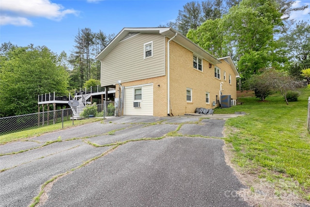 159 Amble Ln, Fletcher, NC 28732 - view of property exterior featuring fence, brick siding, a yard, a wooden deck, and cooling unit